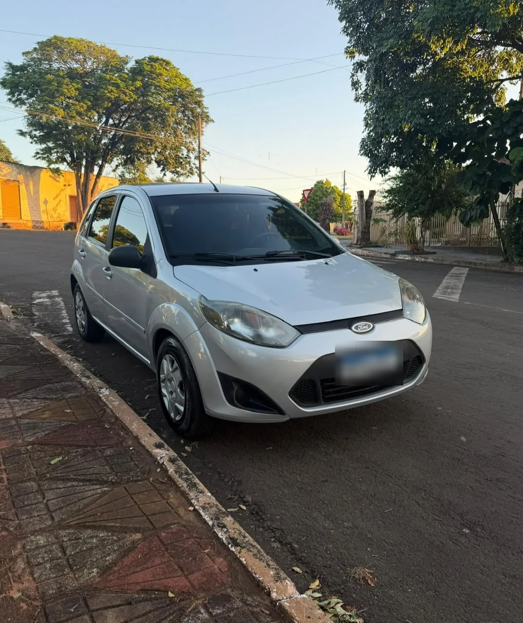 Ford Fiesta 1.6 prata, 2012, de frente em três quartos, estacionado na rua